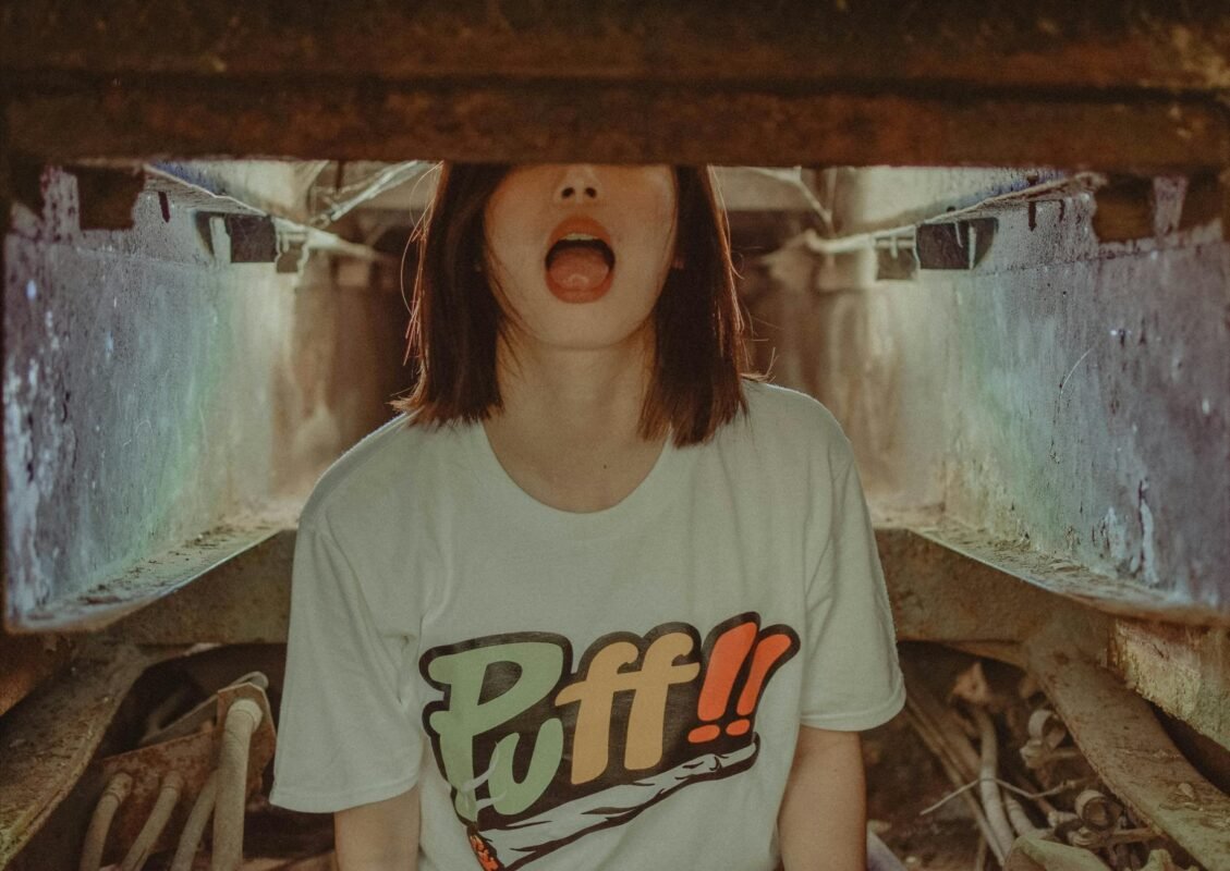 Young woman in a graphic tee showing playful attitude in a gritty, urban environment.